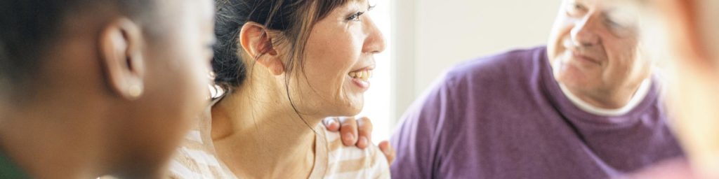 man putting hand on woman's shoulder in therapy