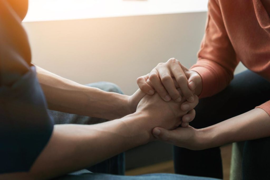people holding hands in cognitive behavioral therapy and addiction treatment