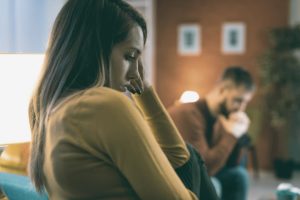 woman and man sitting and listening to causes of drug addiction in women