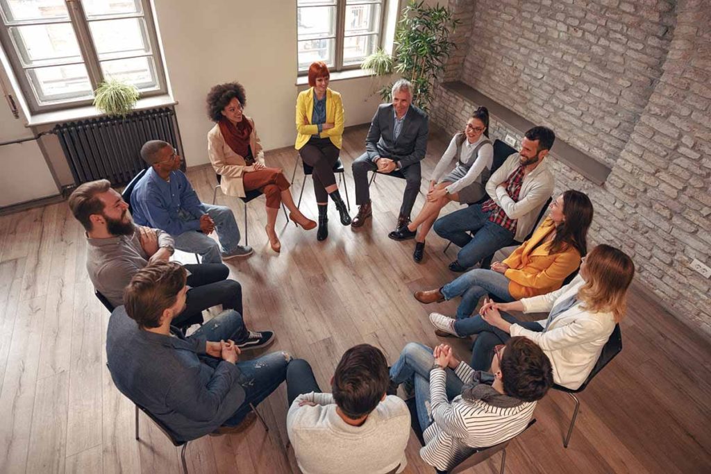 a group sitting and talking is what to expect during a 12-step rehab program