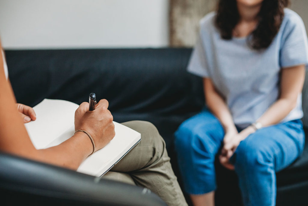 woman patient sitting with a therapist discussing mental health and addiction