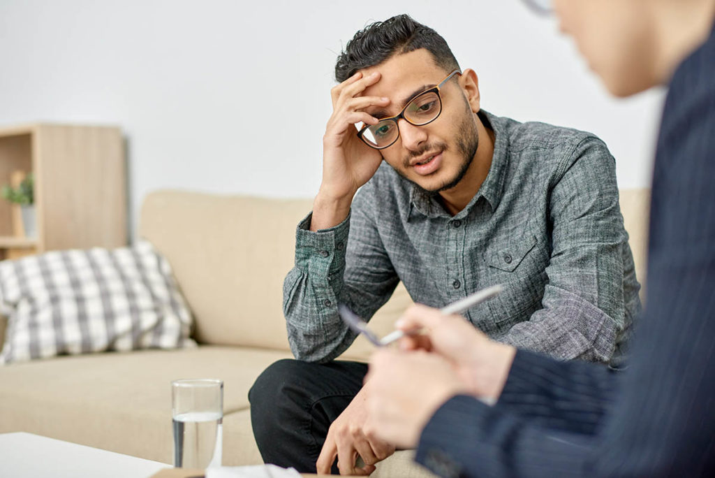 a man sitting with a therapist discussing what is mat