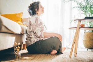 woman in her bedroom practicing meditation and mental health practices