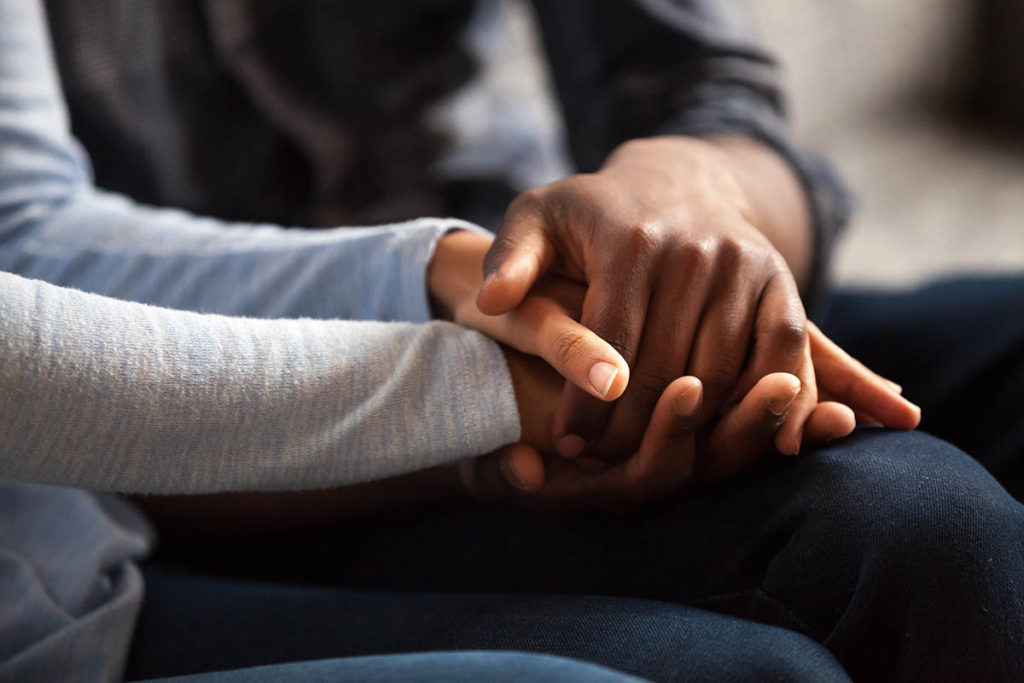 two people holding hands and finding out what it means to be enabling in addiction