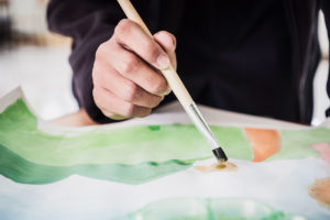 a person painting and experiencing the many benefits of art therapy