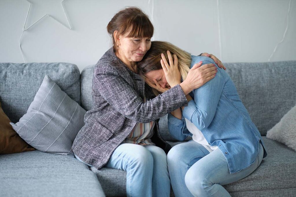 a mother consoles her daughter by hugging her and trying to find out how to talk about depression