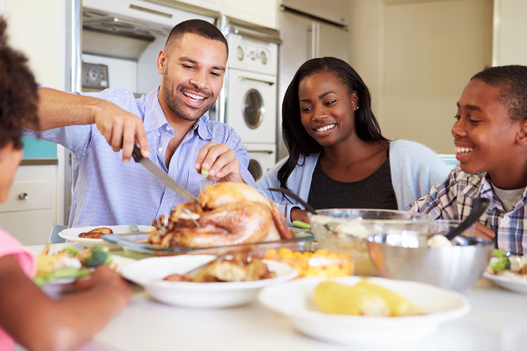 a family enjoys thanksgiving dinner after finding out how to stay sober over thanksgiving