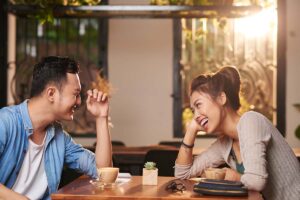 a couple on a date laughs together and discusses what it means to be dating an alcoholic